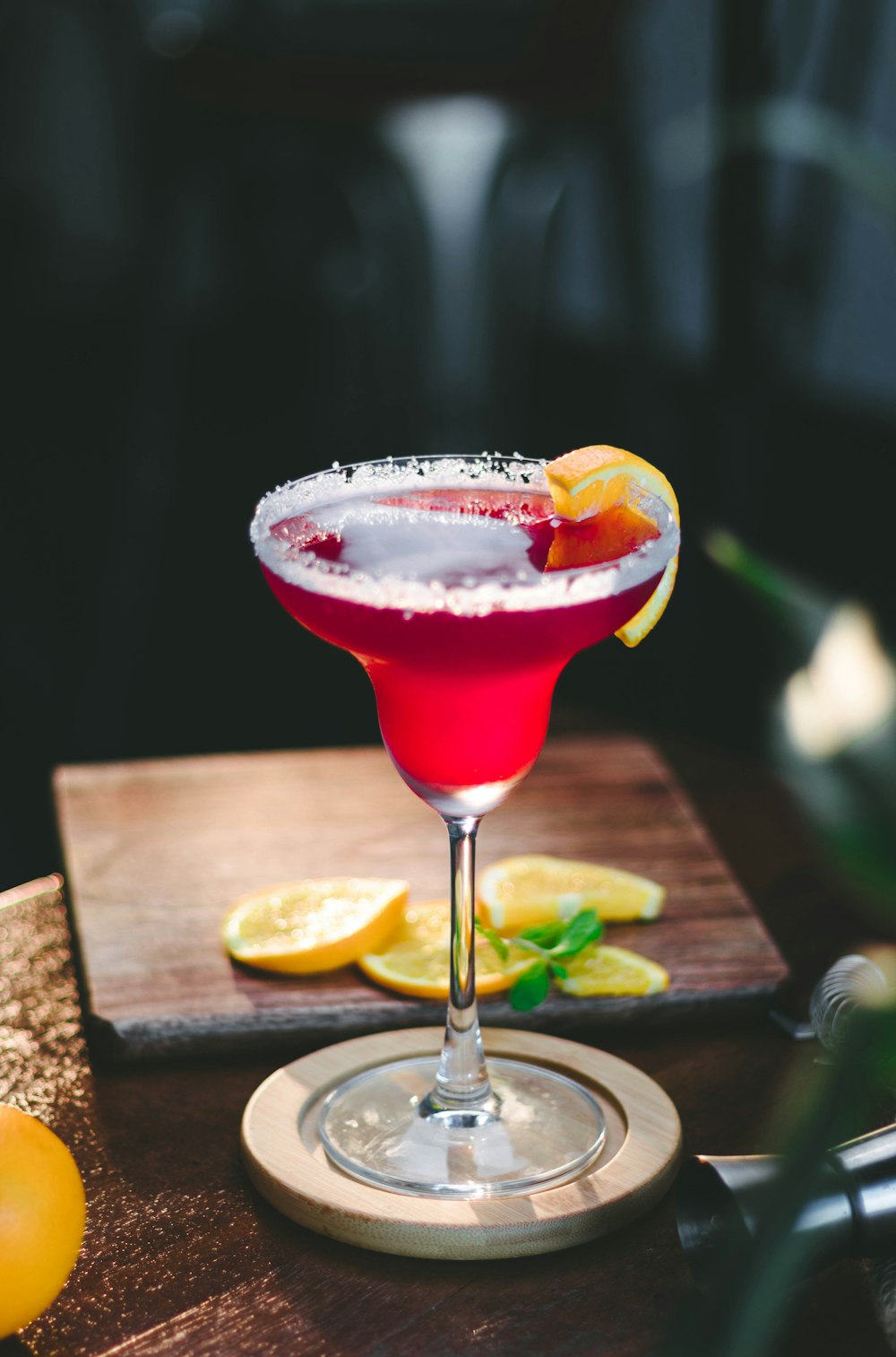 a red cocktail sitting on top of a wooden table