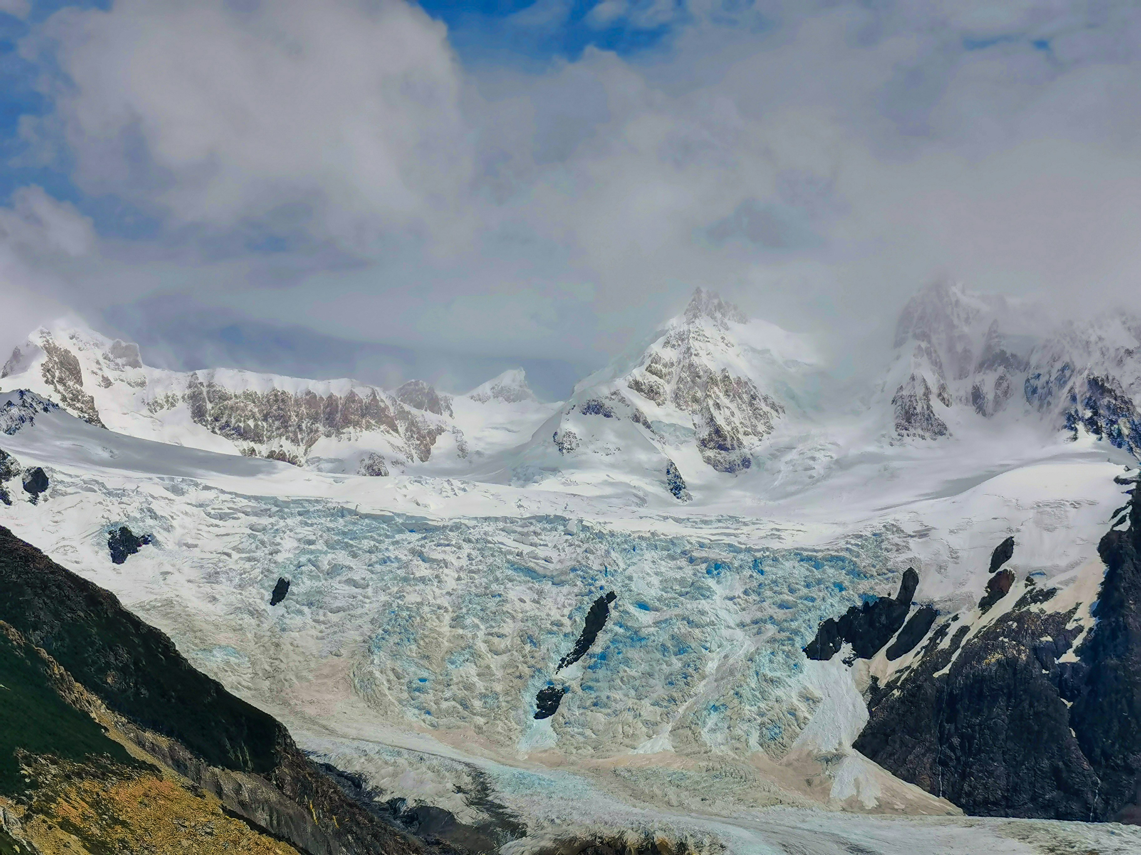 a large glacier with mountains in the background, L