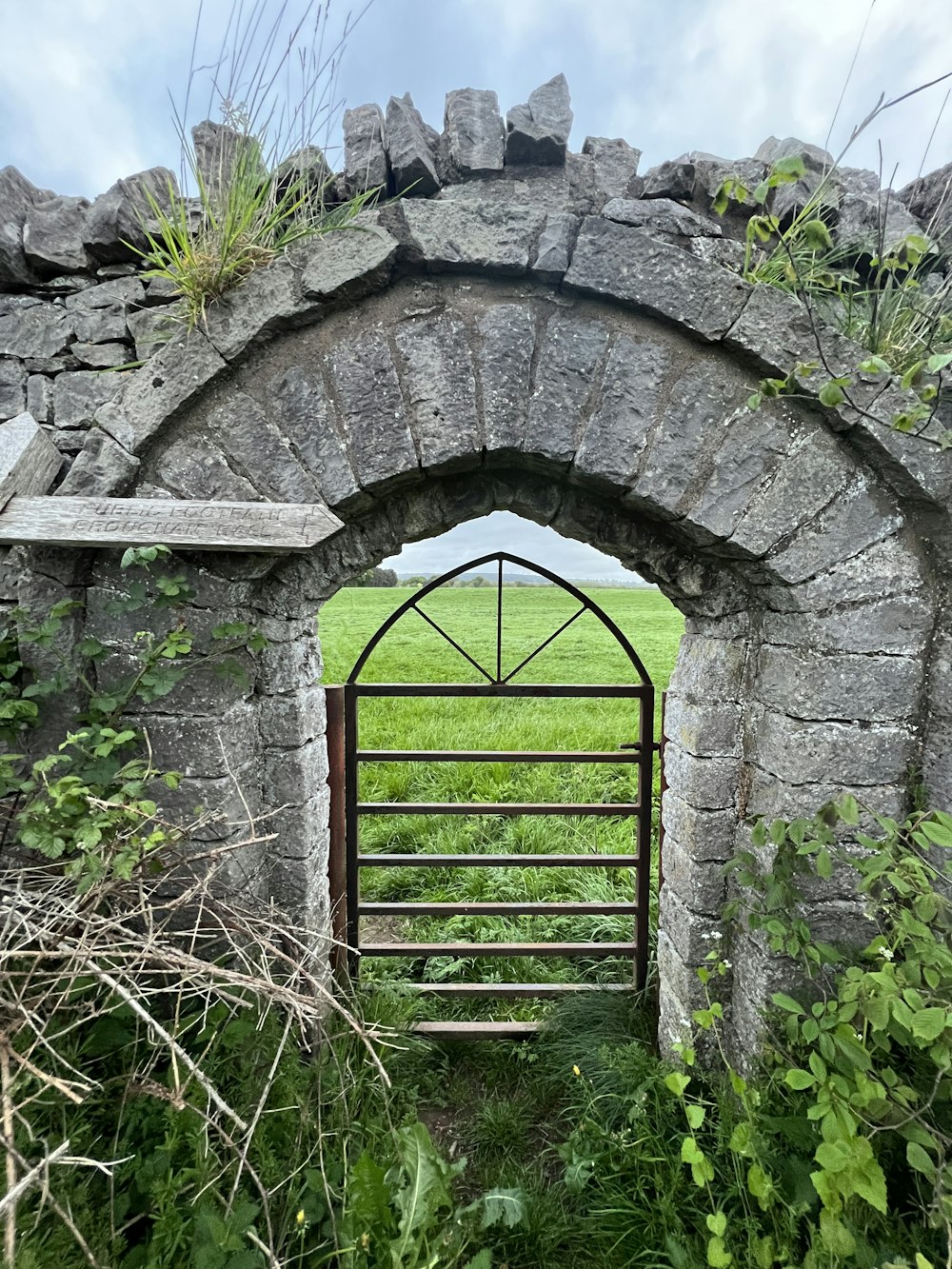 a stone arch with a gate in the middle of it