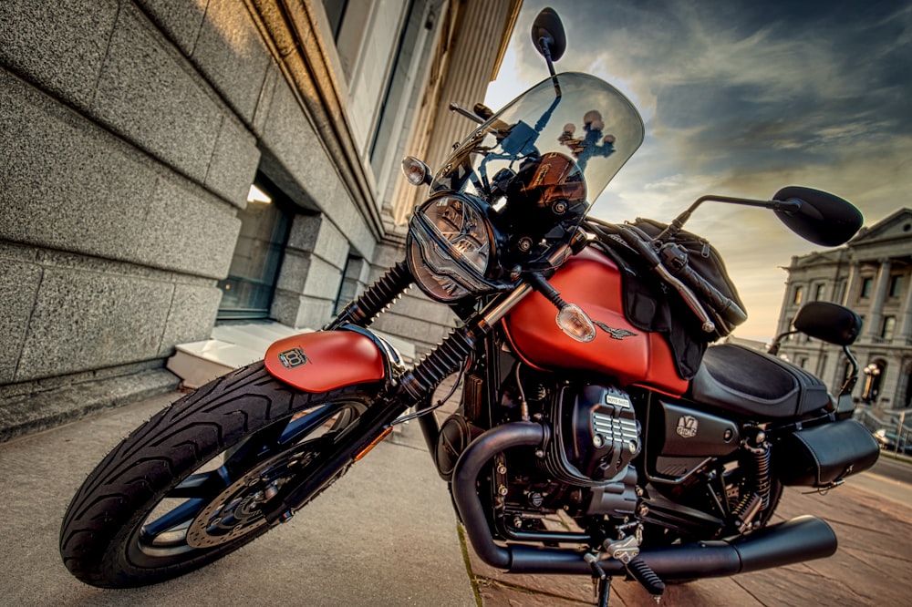 a red and black motorcycle parked on the side of a street