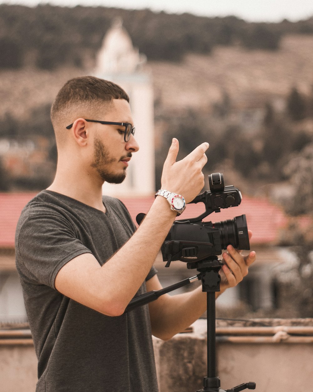 a man standing next to a camera on a tripod