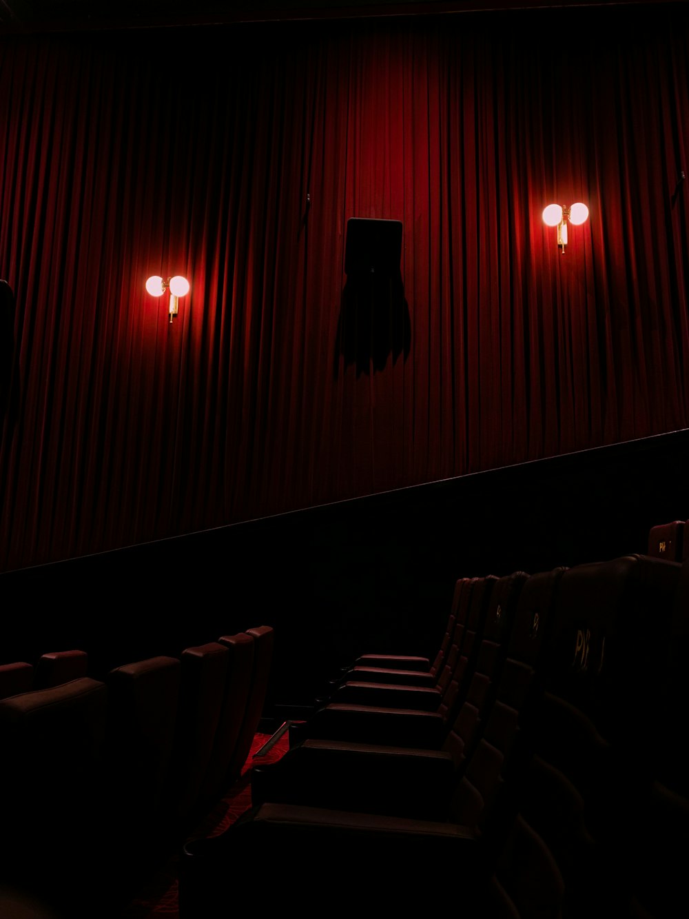 a dark theater with red lights shining on the walls