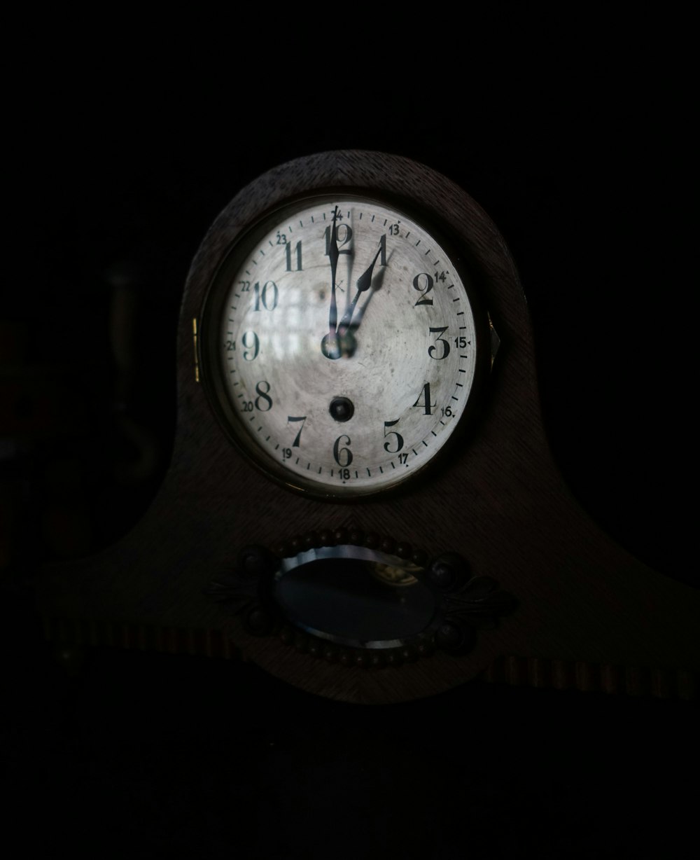 an old clock is lit up in the dark