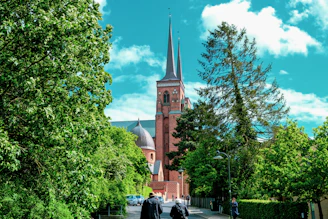 two people walking down a street in front of a church