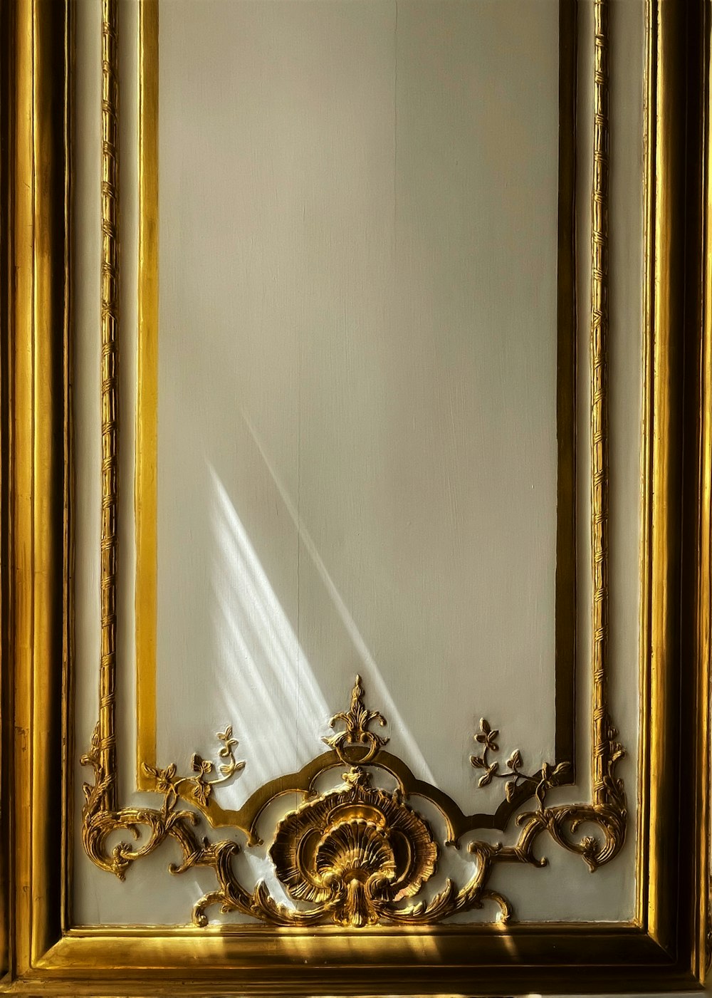 a gold framed mirror with a light shining through it
