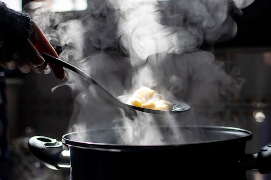 a person stirring food in a pot on a stove