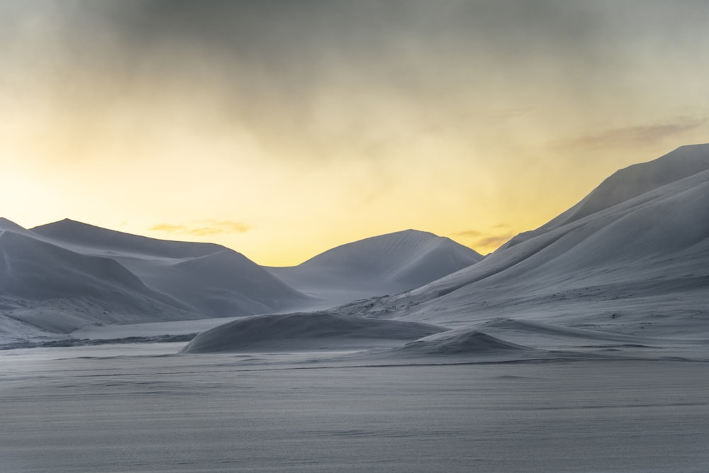 a snow covered landscape with mountains in the distance