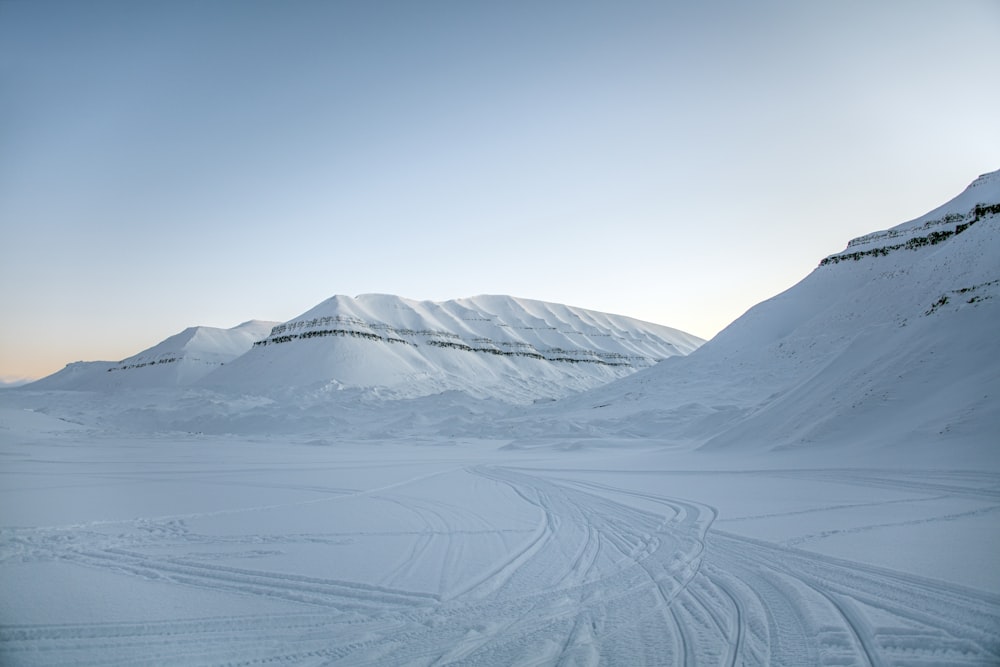 a snow covered mountain with tracks in the snow