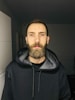a man with a beard wearing a black hoodie