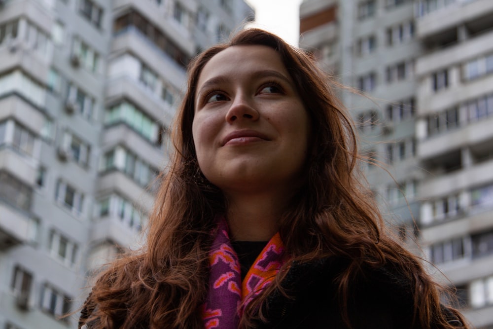 a woman standing in front of a tall building