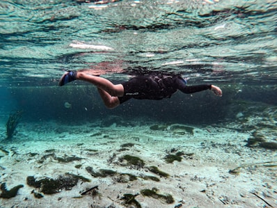 a man swimming in the ocean with his feet in the water
