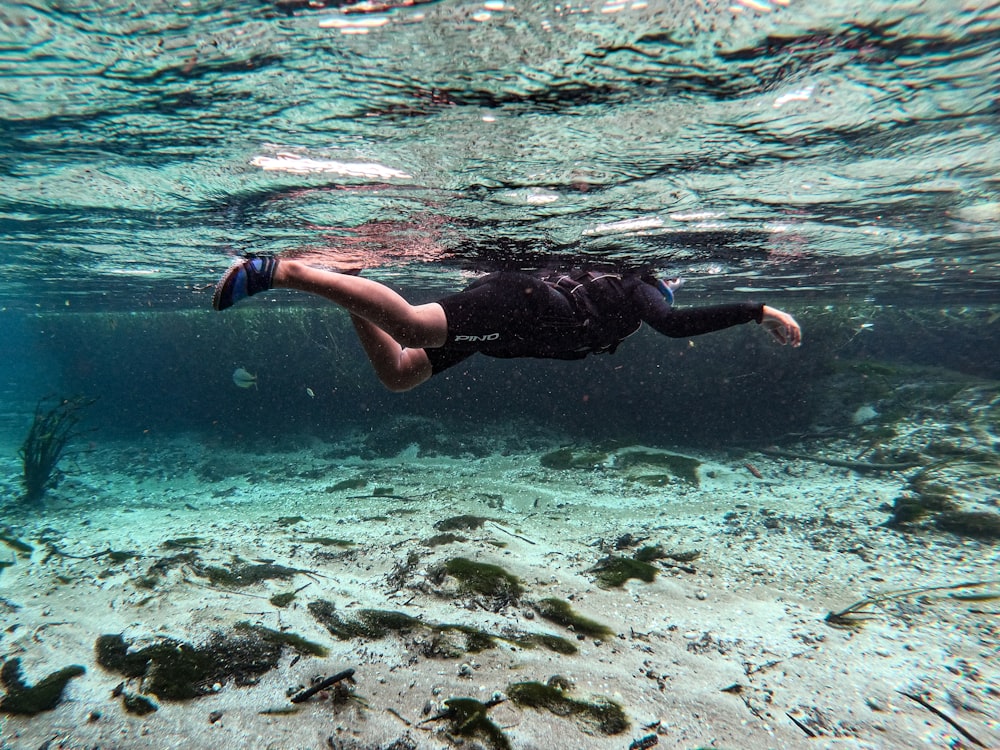 足を水に入れて海を泳ぐ男