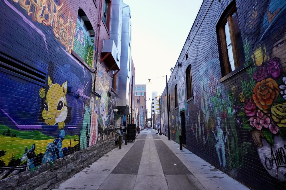 a narrow alley with a lot of graffiti on the walls