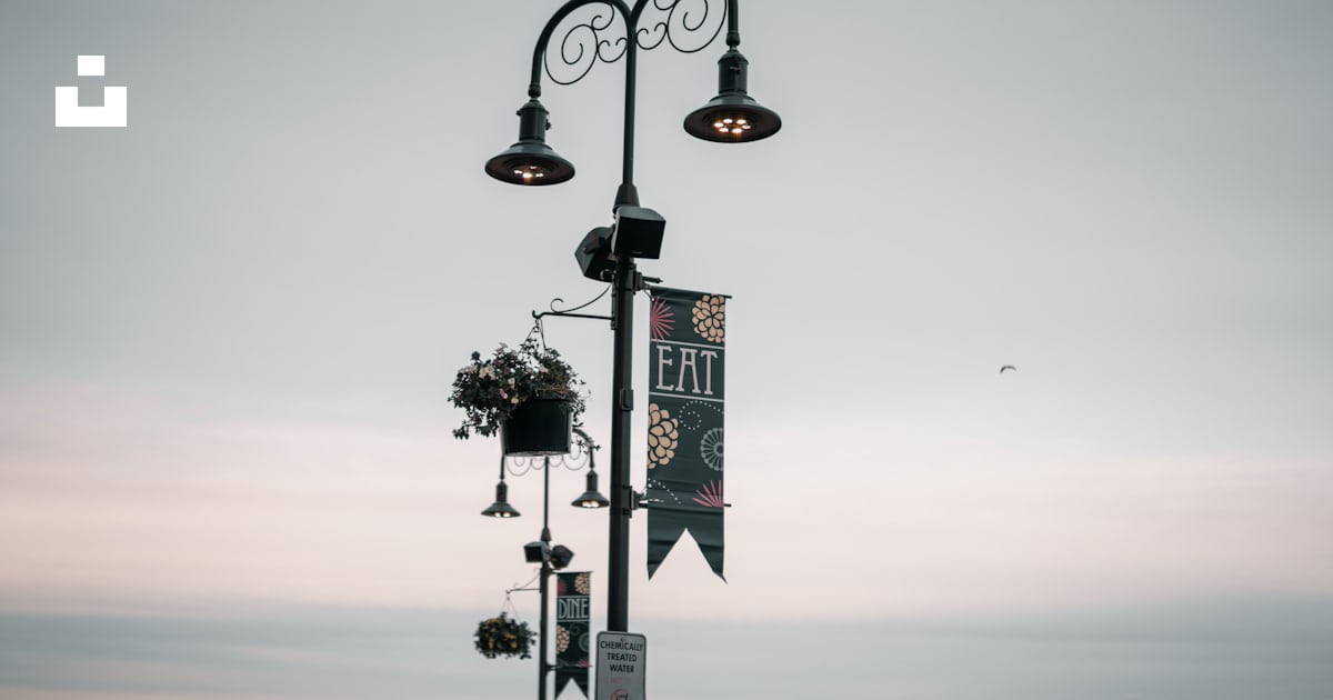 A street light with a sign hanging off of it's side photo – Free Point ...