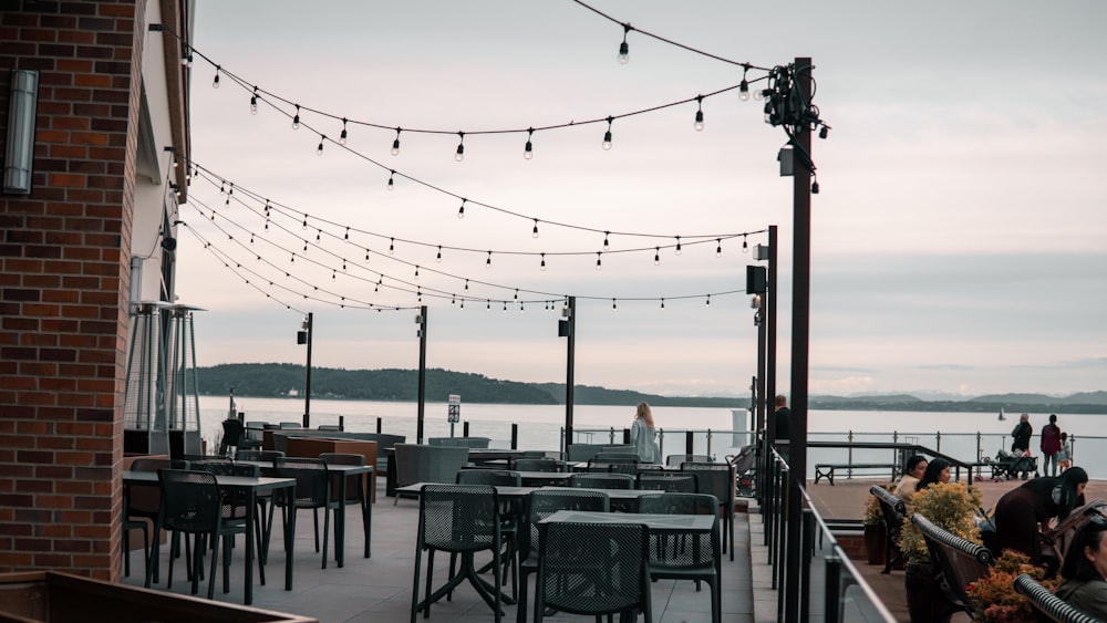 a restaurant with tables and chairs overlooking a body of water