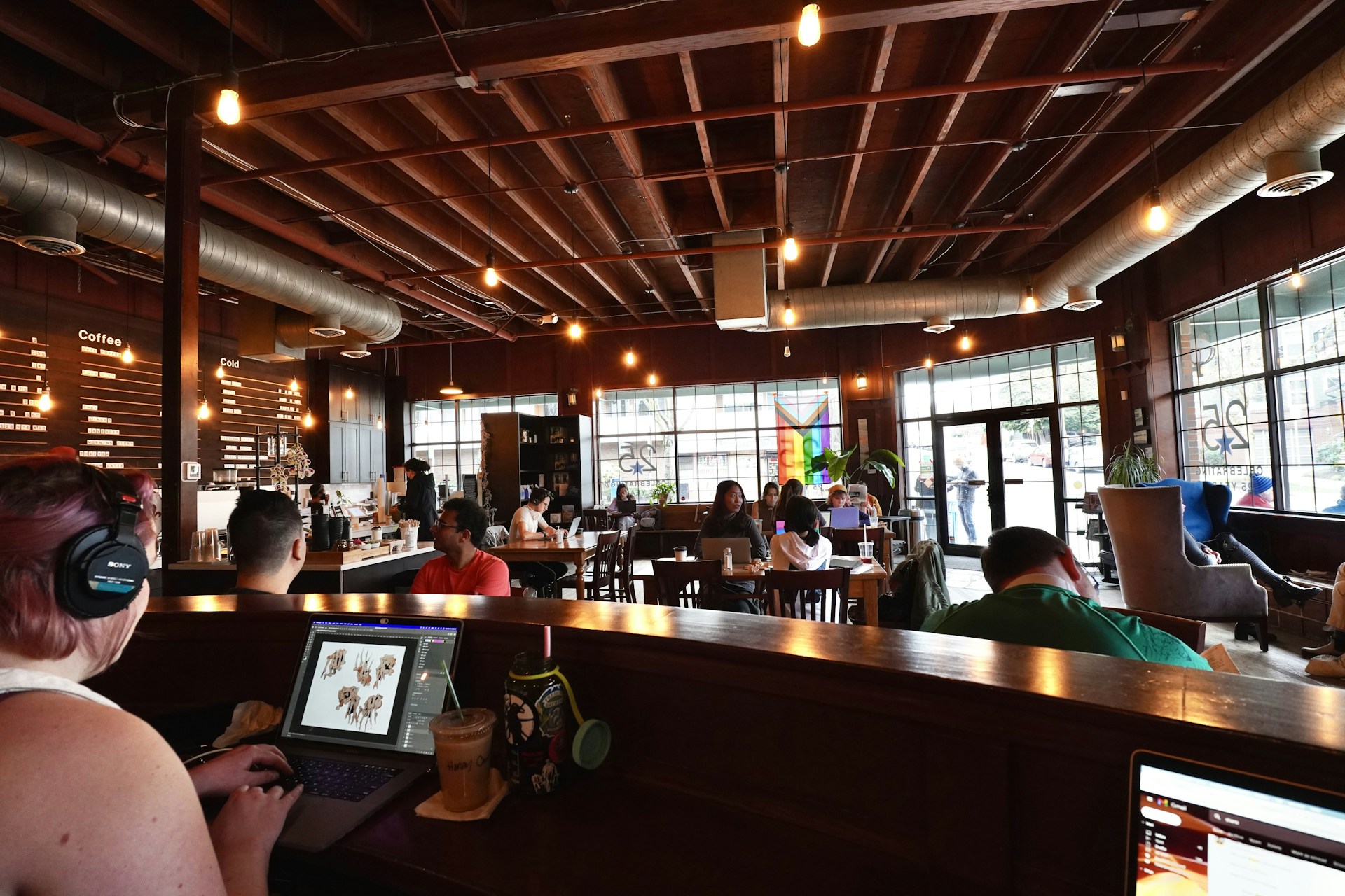 a woman sitting at a bar using a laptop computer