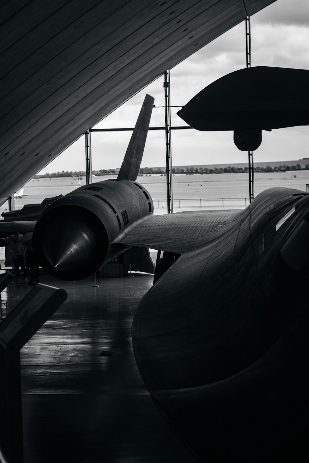 a black and white photo of a plane in a hangar