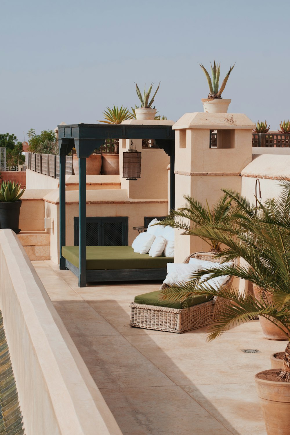 a patio with a couch and potted plants