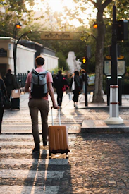 a man pulling a suitcase down a street