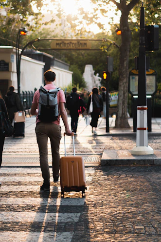 a man pulling a suitcase down a street