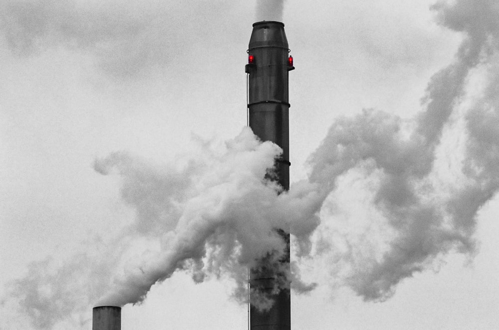 a black and white photo of smoke coming out of a pipe