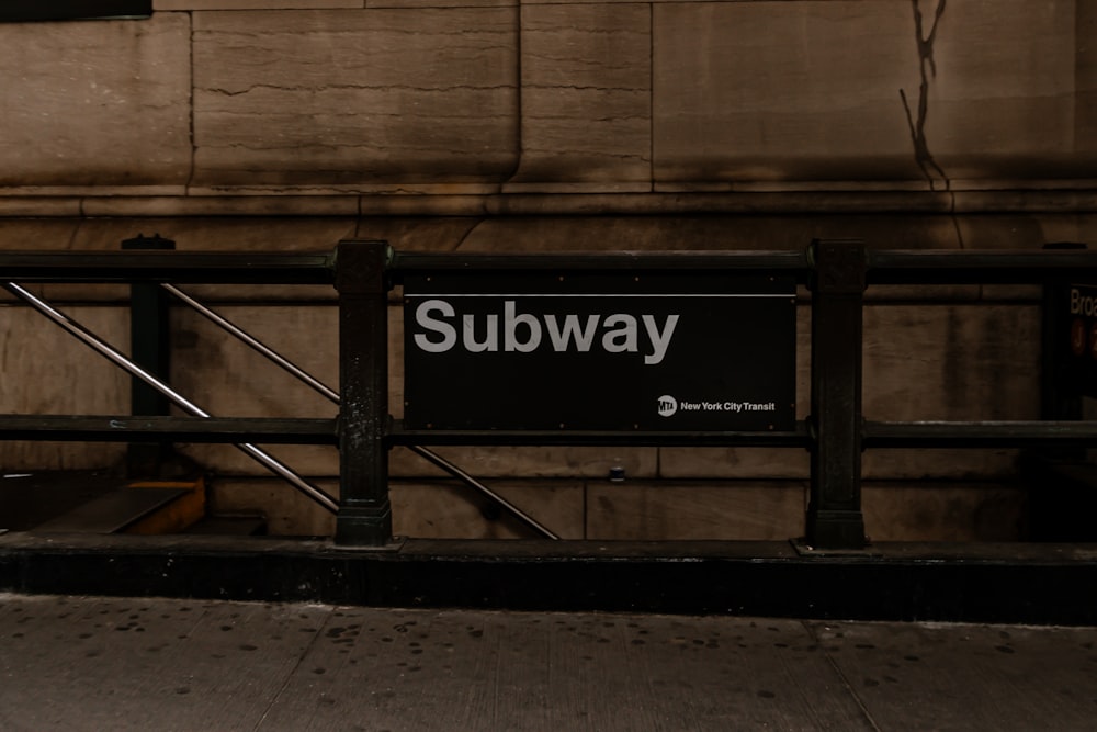 a subway sign sitting on the side of a building