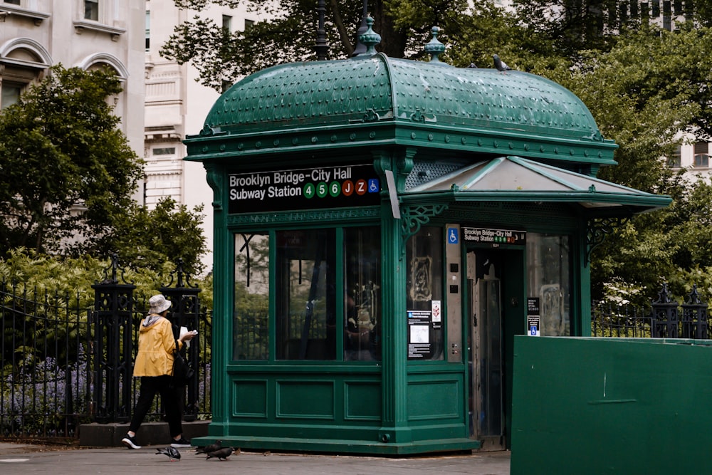 a person standing in front of a green phone booth