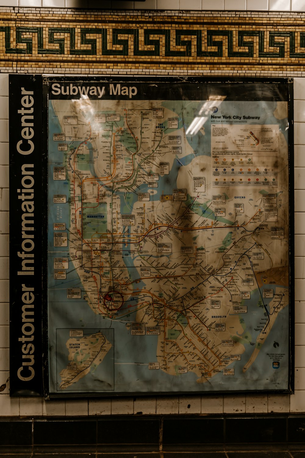a subway map hanging on the wall of a subway station