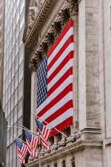 a large american flag hanging from the side of a building