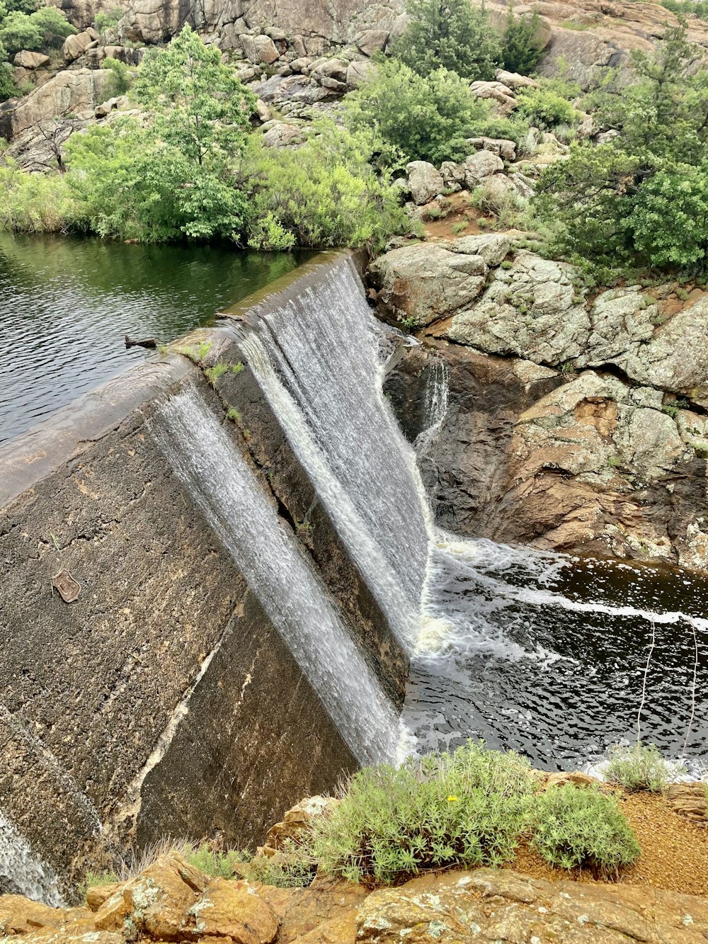 a waterfall with a man standing on top of it