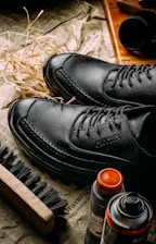 a pair of black shoes sitting on top of a newspaper