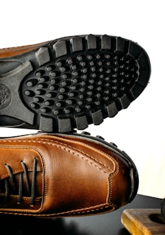 a pair of brown shoes sitting on top of a table