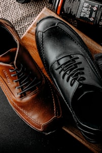 a pair of black and brown shoes sitting on top of a table