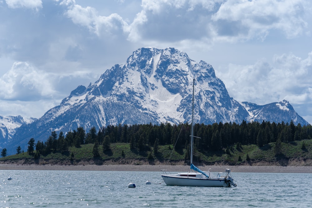 a sailboat in the water with a mountain in the background