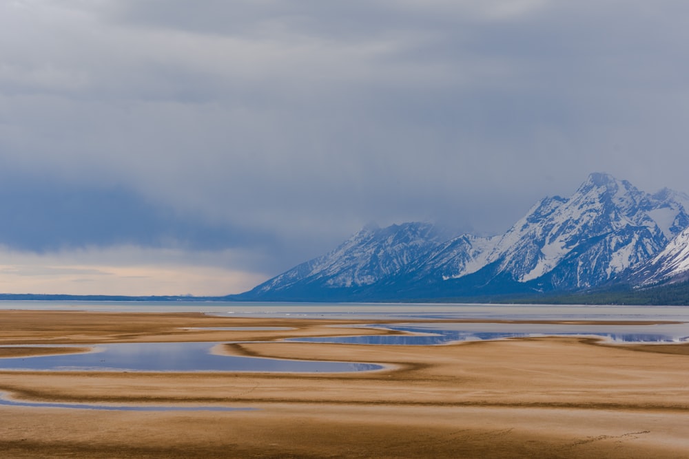 a mountain range with a body of water in the foreground