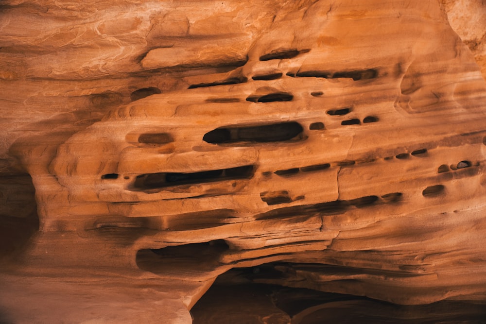 a rock formation with holes in the side of it