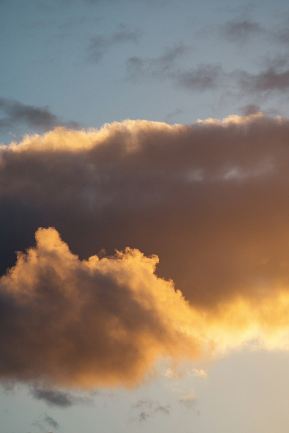 um avião voando através de um céu nublado ao pôr do sol