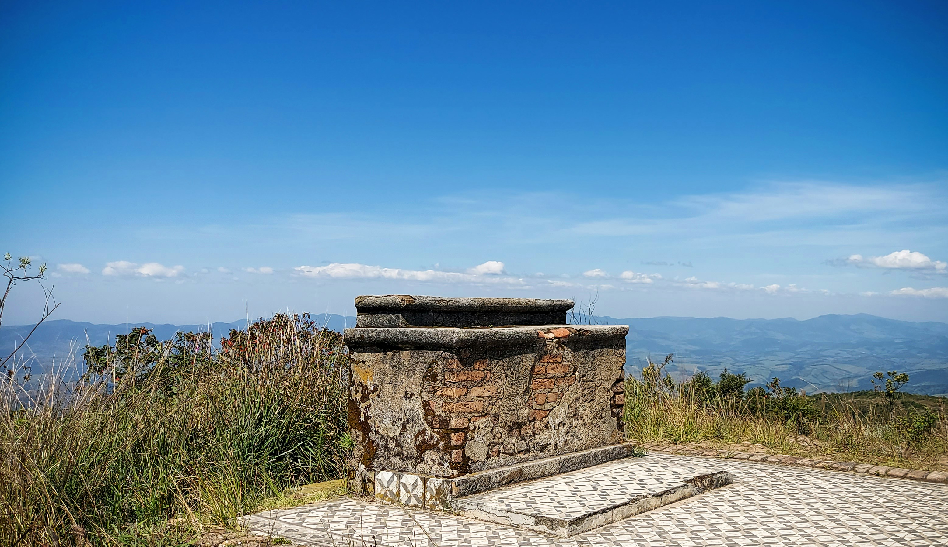 a stone bench sitting on top of a hill