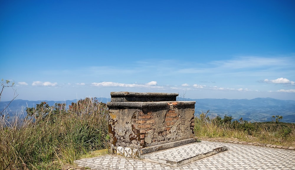 una panchina di pietra seduta sulla cima di una collina