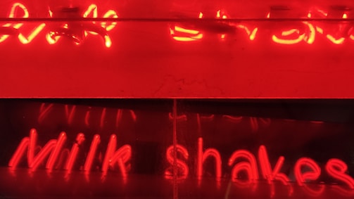 3D-rendered glowing milk bottles floating above a frosted glass card with neon green accents.