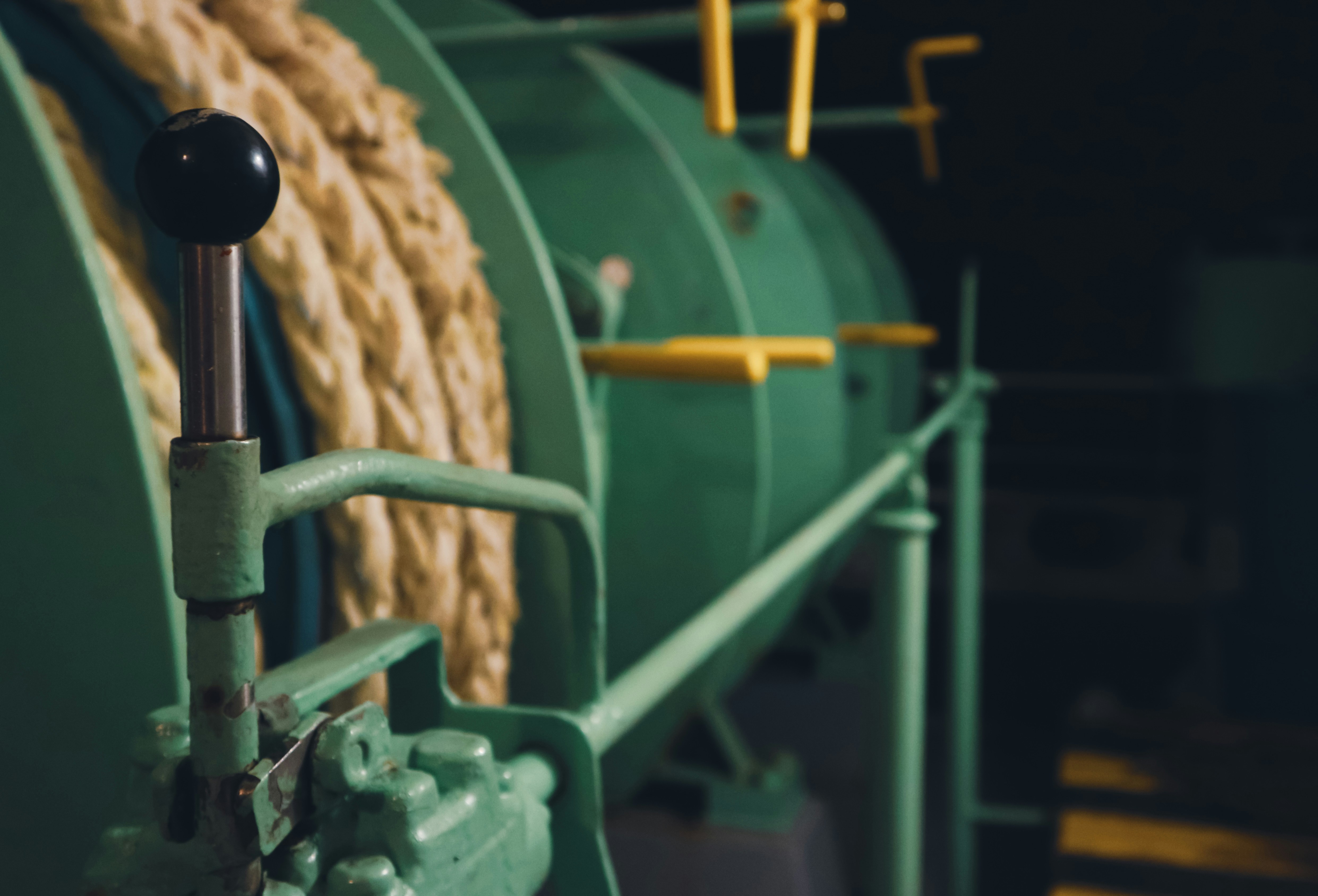 a large green machine with a rope on top of it