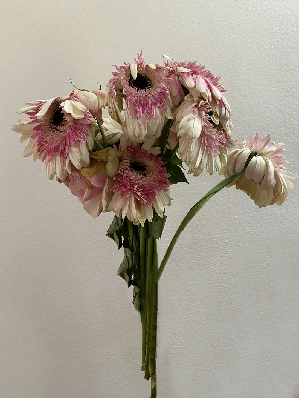 a vase filled with lots of pink and white flowers