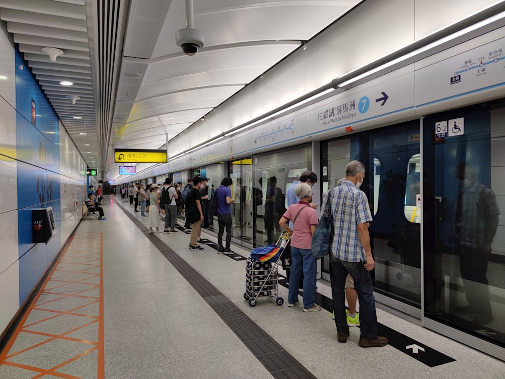 a group of people standing next to a train