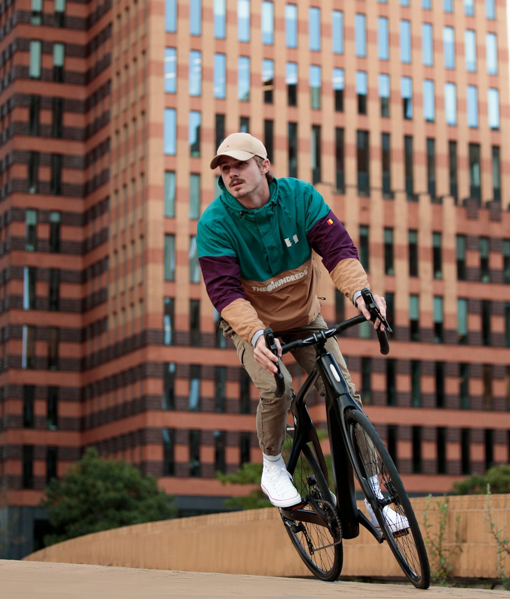 a man riding a bike in front of a tall building