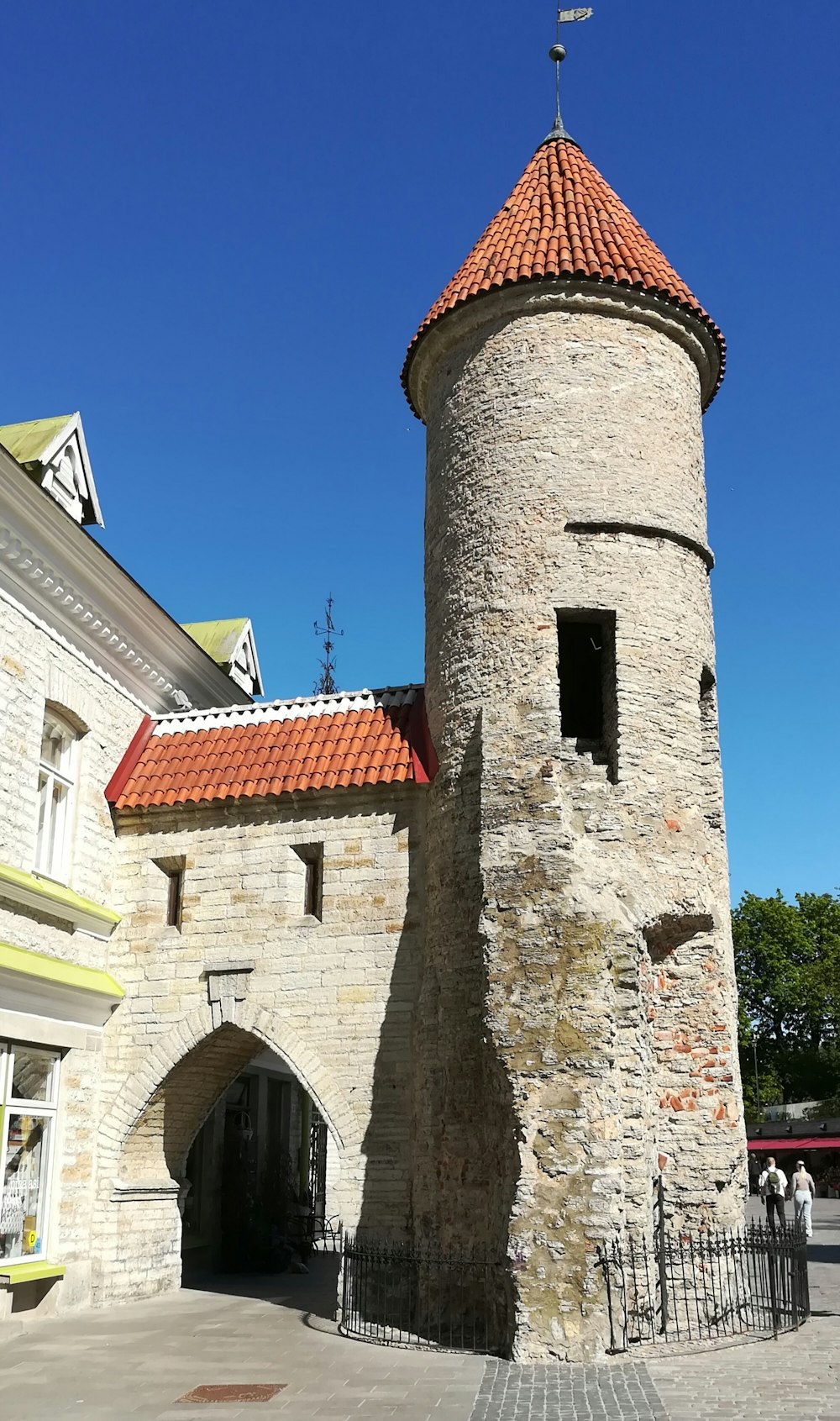 a stone tower with a red tiled roof