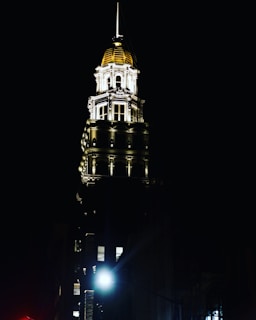 The exterior of the International Affairs & Anti-Corruption Tribunal building at dusk, illuminated in black and gold.