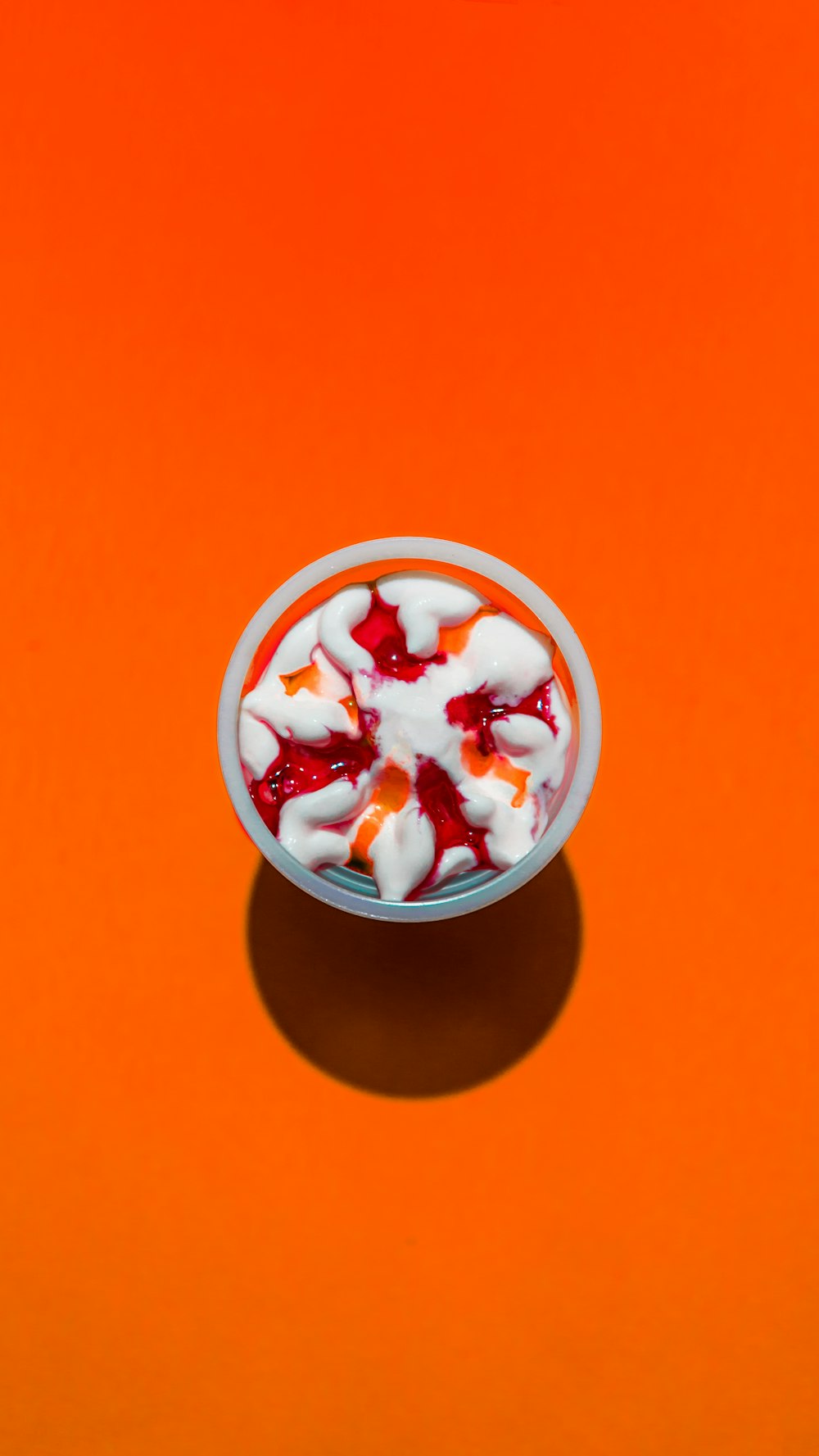 a white bowl filled with fruit on top of an orange table