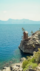 Modern wooden cabin with large windows overlooking a serene lake.