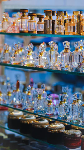 A display of Al Battar's eleven perfume bottles arranged elegantly on a wooden shelf.