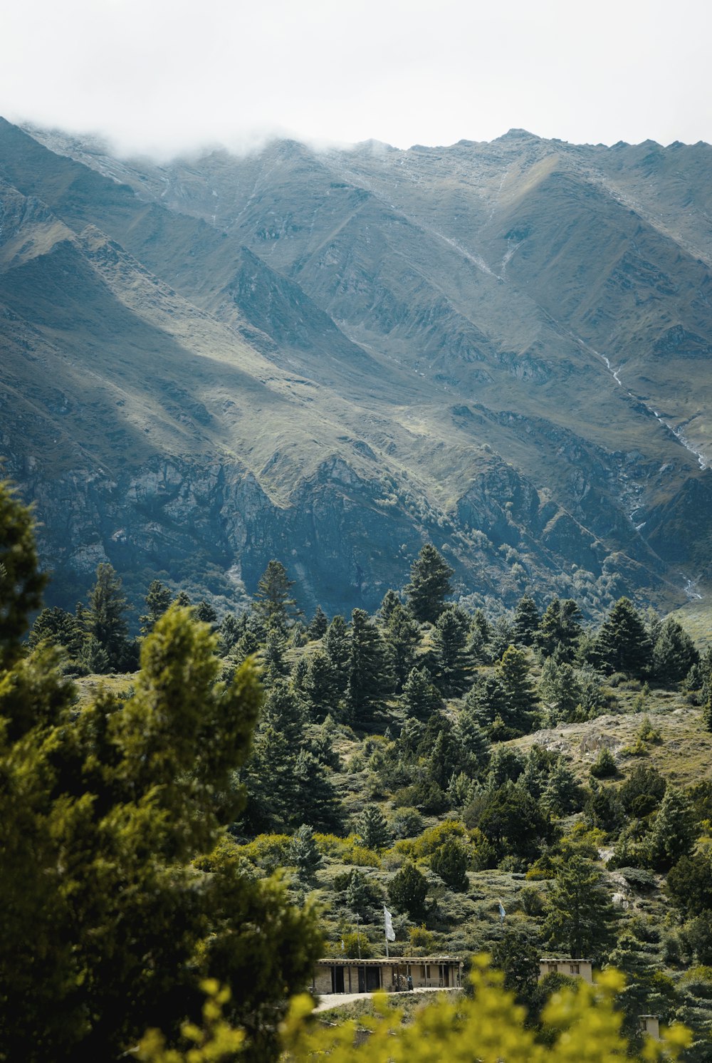 a scenic view of a mountain range with a bridge in the foreground